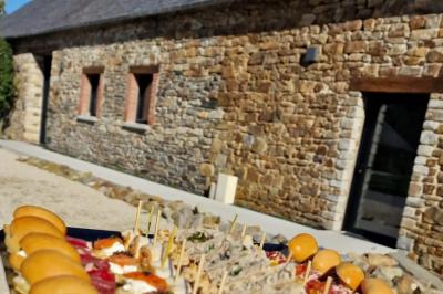 Miniature Location salle Domagné (Ille-et-Vilaine) - Domaine de Neuville #17 Assiette contenant des cookies et un petit gâteau sur une table noire, avec des verres et un vase décoratif à proximité.