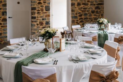 Miniature Location salle Domagné (Ille-et-Vilaine) - Domaine de Neuville #7 Assiette contenant des cookies et un petit gâteau sur une table noire, avec des verres et un vase décoratif à proximité.