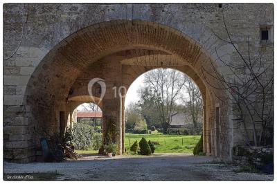 Miniature Location salle Cezais (Vendée) - Château de la Cressonnière #2 Un homme debout, bras ouverts, s'exprime devant un mur en pierre, avec une chaise en bois à côté de lui.