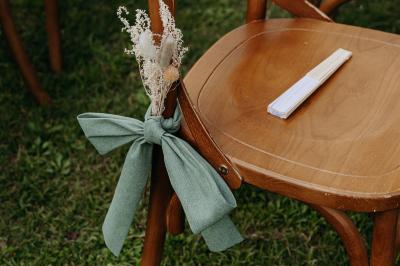 Miniature Location salle Cezais (Vendée) - Château de la Cressonnière #3 Un homme debout, bras ouverts, s'exprime devant un mur en pierre, avec une chaise en bois à côté de lui.