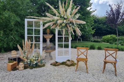 Miniature Location salle Cezais (Vendée) - Château de la Cressonnière #7 Un homme debout, bras ouverts, s'exprime devant un mur en pierre, avec une chaise en bois à côté de lui.