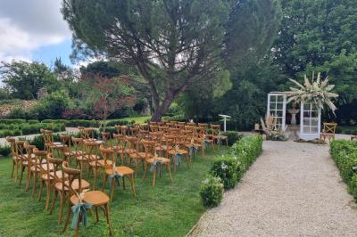 Miniature Location salle Cezais (Vendée) - Château de la Cressonnière #8 Un homme debout, bras ouverts, s'exprime devant un mur en pierre, avec une chaise en bois à côté de lui.