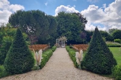 Miniature Location salle Cezais (Vendée) - Château de la Cressonnière #10 Un homme debout, bras ouverts, s'exprime devant un mur en pierre, avec une chaise en bois à côté de lui.