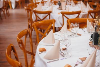 Miniature Location salle Cezais (Vendée) - Château de la Cressonnière #34 Un homme debout, bras ouverts, s'exprime devant un mur en pierre, avec une chaise en bois à côté de lui.