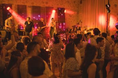 Miniature Location salle Cezais (Vendée) - Château de la Cressonnière #38 Un homme debout, bras ouverts, s'exprime devant un mur en pierre, avec une chaise en bois à côté de lui.