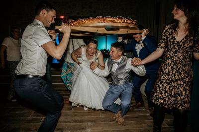 Miniature Location salle Cezais (Vendée) - Château de la Cressonnière #41 Un homme debout, bras ouverts, s'exprime devant un mur en pierre, avec une chaise en bois à côté de lui.