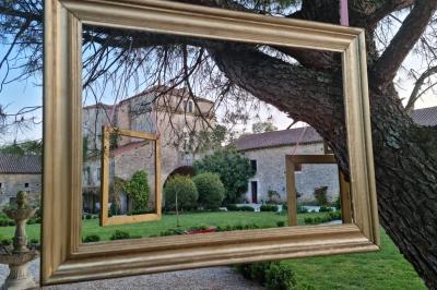Miniature Location salle Cezais (Vendée) - Château de la Cressonnière #18 Un homme debout, bras ouverts, s'exprime devant un mur en pierre, avec une chaise en bois à côté de lui.