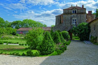 Miniature Location salle Cezais (Vendée) - Château de la Cressonnière #21 Un homme debout, bras ouverts, s'exprime devant un mur en pierre, avec une chaise en bois à côté de lui.