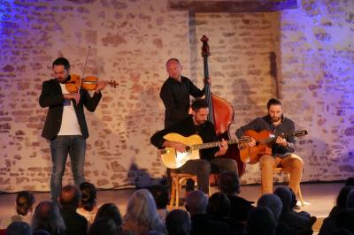 Miniature Location salle Cezais (Vendée) - Château de la Cressonnière #43 Un homme debout, bras ouverts, s'exprime devant un mur en pierre, avec une chaise en bois à côté de lui.