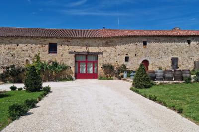 Miniature Location salle Cezais (Vendée) - Château de la Cressonnière #22 Un homme debout, bras ouverts, s'exprime devant un mur en pierre, avec une chaise en bois à côté de lui.