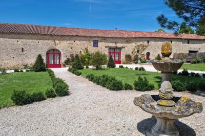 Miniature Location salle Cezais (Vendée) - Château de la Cressonnière #23 Un homme debout, bras ouverts, s'exprime devant un mur en pierre, avec une chaise en bois à côté de lui.
