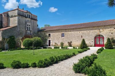 Miniature Location salle Cezais (Vendée) - Château de la Cressonnière #24 Un homme debout, bras ouverts, s'exprime devant un mur en pierre, avec une chaise en bois à côté de lui.