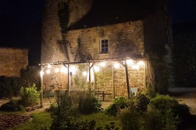 Miniature Location salle Cezais (Vendée) - Château de la Cressonnière #32 Un homme debout, bras ouverts, s'exprime devant un mur en pierre, avec une chaise en bois à côté de lui.