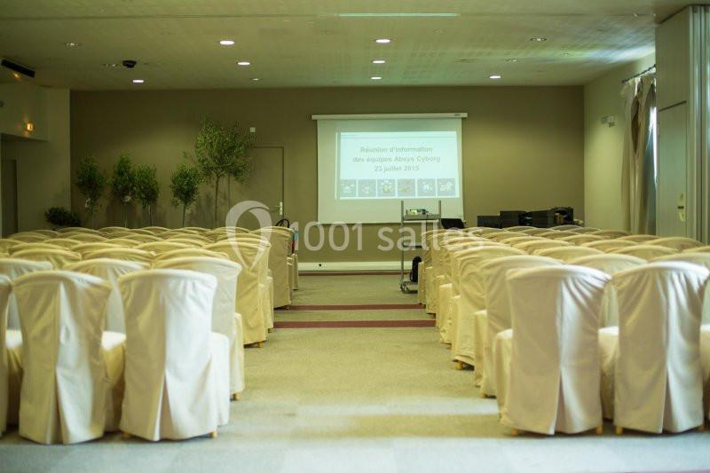 Location salle Marseille 11 (Bouches-du-Rhône) - La Bastide de la Salette #5 Salle de conférence vide avec des rangées de chaises blanches et un écran de projection affichant une présentation.