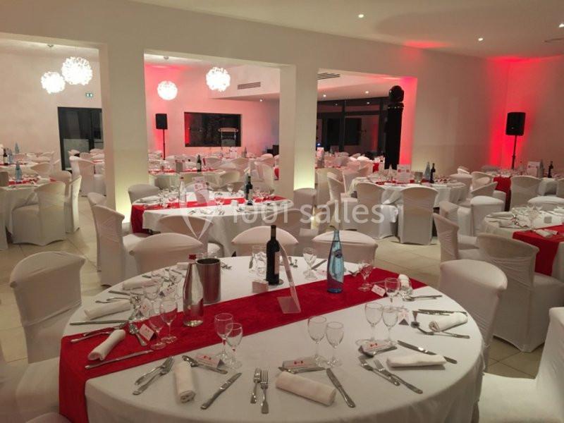 Location salle Marseille 11 (Bouches-du-Rhône) - La Bastide de la Salette #9 Salle de réception décorée avec des tables rondes, nappes blanches, chemins de table rouges et chaises habillées.