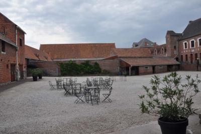 Miniature Location salle Péruwelz (Hainaut) - La Ferme de Bouchegnies #27 Salle de réception en briques avec tables rondes dressées, nappes blanches et décoration de mariage.