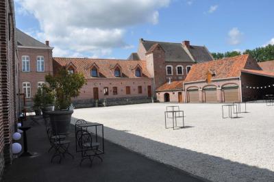Miniature Location salle Péruwelz (Hainaut) - La Ferme de Bouchegnies #19 Salle de réception en briques avec tables rondes dressées, nappes blanches et décoration de mariage.