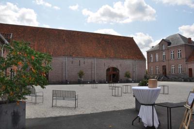 Miniature Location salle Péruwelz (Hainaut) - La Ferme de Bouchegnies #32 Salle de réception en briques avec tables rondes dressées, nappes blanches et décoration de mariage.