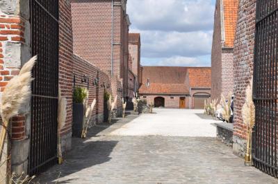 Miniature Location salle Péruwelz (Hainaut) - La Ferme de Bouchegnies #34 Salle de réception en briques avec tables rondes dressées, nappes blanches et décoration de mariage.