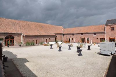 Miniature Location salle Péruwelz (Hainaut) - La Ferme de Bouchegnies #28 Salle de réception en briques avec tables rondes dressées, nappes blanches et décoration de mariage.