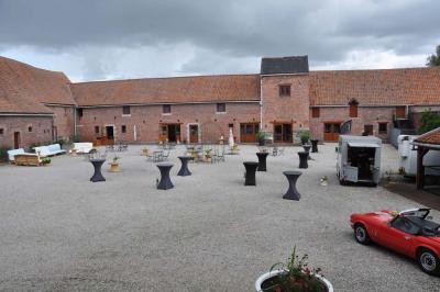 Miniature Location salle Péruwelz (Hainaut) - La Ferme de Bouchegnies #39 Salle de réception en briques avec tables rondes dressées, nappes blanches et décoration de mariage.