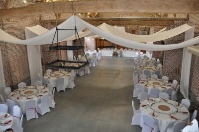 Miniature Location salle Péruwelz (Hainaut) - La Ferme de Bouchegnies #12 Salle de réception en briques avec tables rondes dressées, nappes blanches et décoration de mariage.