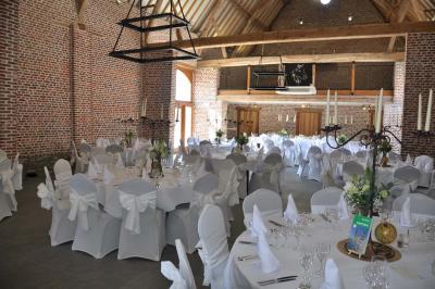 Miniature Location salle Péruwelz (Hainaut) - La Ferme de Bouchegnies #13 Salle de réception en briques avec tables rondes dressées, nappes blanches et décoration de mariage.