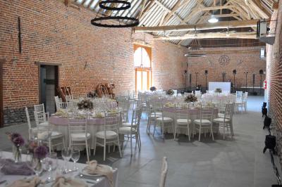 Miniature Location salle Péruwelz (Hainaut) - La Ferme de Bouchegnies #3 Salle de réception en briques avec tables rondes dressées, nappes blanches et décoration de mariage.
