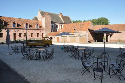 Miniature Location salle Péruwelz (Hainaut) - La Ferme de Bouchegnies #20 Salle de réception en briques avec tables rondes dressées, nappes blanches et décoration de mariage.