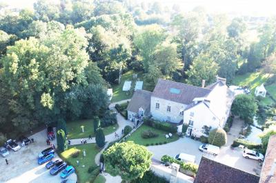 Un couple en tenue de mariage se tient sur un balcon en pierre devant une fenêtre illuminée.