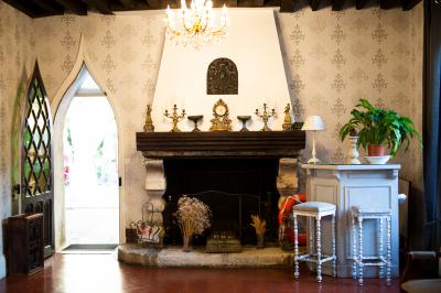 Un couple en tenue de mariage se tient sur un balcon en pierre devant une fenêtre illuminée.
