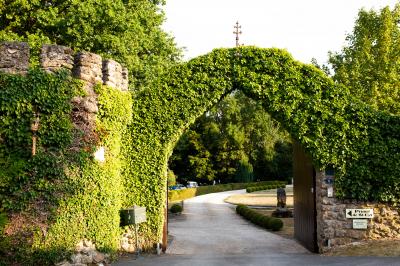Un couple en tenue de mariage se tient sur un balcon en pierre devant une fenêtre illuminée.