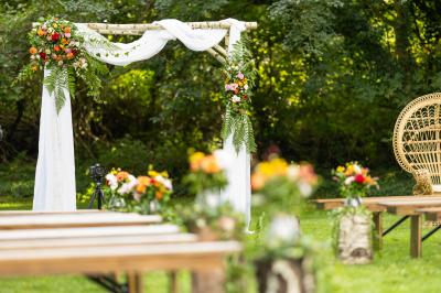 Un couple en tenue de mariage se tient sur un balcon en pierre devant une fenêtre illuminée.