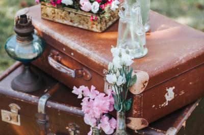 Deux tentes blanches montées sur une pelouse avec des tables et des chaises disposées autour, entourées de verdure.