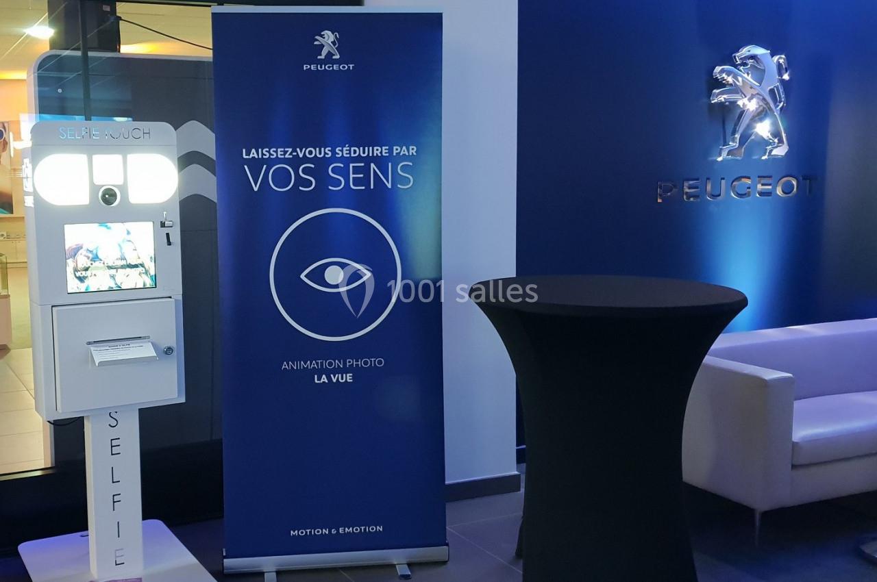 Borne photo interactive et panneau promotionnel Peugeot dans un espace intérieur moderne et éclairé.