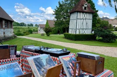 Miniature Location salle Harquency (Eure) - La Grange de Bourgoult #80 Platines vinyles et disques exposés sur une table en extérieur, avec un jardin verdoyant et un pigeonnier à colombages en…