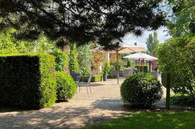Brasero allumé dans une cour gravillonnée devant un bâtiment éclairé avec des murs en bois et des portes vitrées.