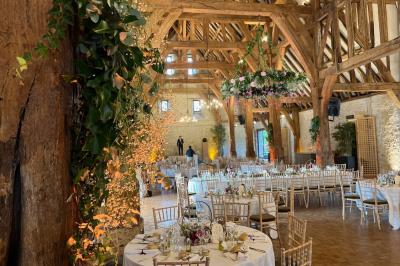 Brasero allumé dans une cour gravillonnée devant un bâtiment éclairé avec des murs en bois et des portes vitrées.