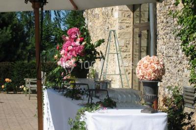 Brasero allumé dans une cour gravillonnée devant un bâtiment éclairé avec des murs en bois et des portes vitrées.
