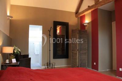 Brasero allumé dans une cour gravillonnée devant un bâtiment éclairé avec des murs en bois et des portes vitrées.