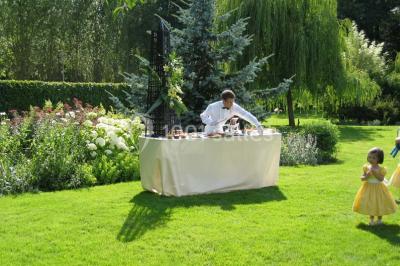 Brasero allumé dans une cour gravillonnée devant un bâtiment éclairé avec des murs en bois et des portes vitrées.
