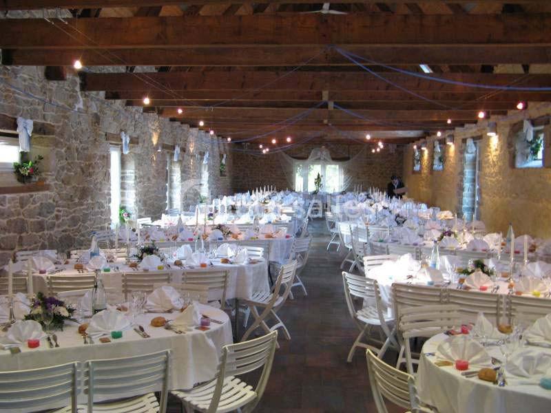 Location salle Douarnenez (Finistère) - La Ferme de Trézulien #5 Salle en pierre avec des tables rondes dressées pour un événement, décorée de nappes blanches et éclairée par des guirlandes.
