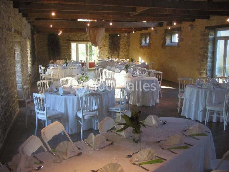Location salle Douarnenez (Finistère) - La Ferme de Trézulien #10 Salle de réception en pierre avec tables rondes dressées de nappes blanches, chaises assorties et décoration élégante.