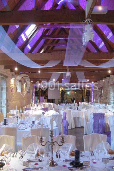 Location salle Douarnenez (Finistère) - La Ferme de Trézulien #12 Salle de réception décorée avec des nappes blanches, des voilages suspendus et un éclairage violet.