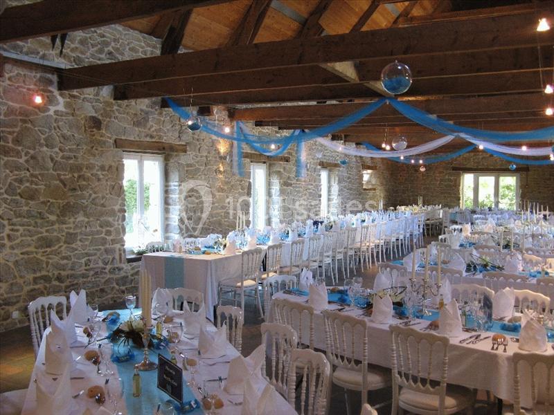 Location salle Douarnenez (Finistère) - La Ferme de Trézulien #16 Salle de réception en pierre avec tables décorées en blanc et bleu, préparées pour un événement festif.