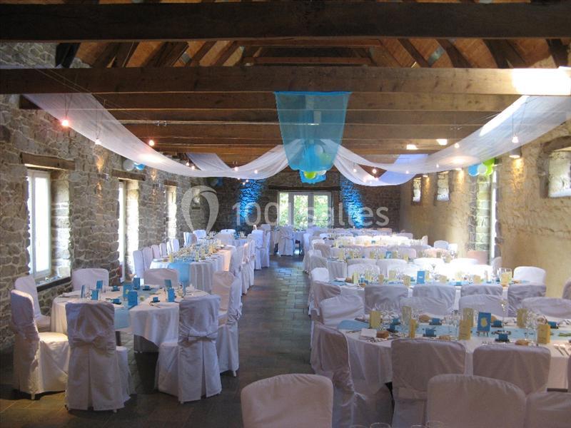 Location salle Douarnenez (Finistère) - La Ferme de Trézulien #14 Salle en pierre avec poutres apparentes, décorée pour un événement, tables dressées avec nappes blanches et voilages…