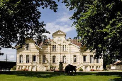 Miniature Location salle Moulis-en-Médoc (Gironde) - Château Maucaillou #14 Salle à manger élégante avec table dressée, bouquet de fleurs au centre, grande fenêtre ouverte sur un jardin verdoyant.