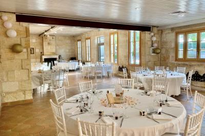 Miniature Location salle Moulis-en-Médoc (Gironde) - Château Maucaillou #19 Salle à manger élégante avec table dressée, bouquet de fleurs au centre, grande fenêtre ouverte sur un jardin verdoyant.