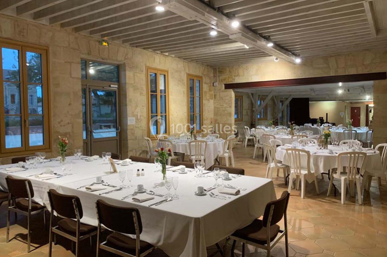 Location salle Moulis-en-Médoc (Gironde) - Château Maucaillou #17 Salle de réception lumineuse avec tables dressées, nappes blanches et chaises, prête pour un événement.