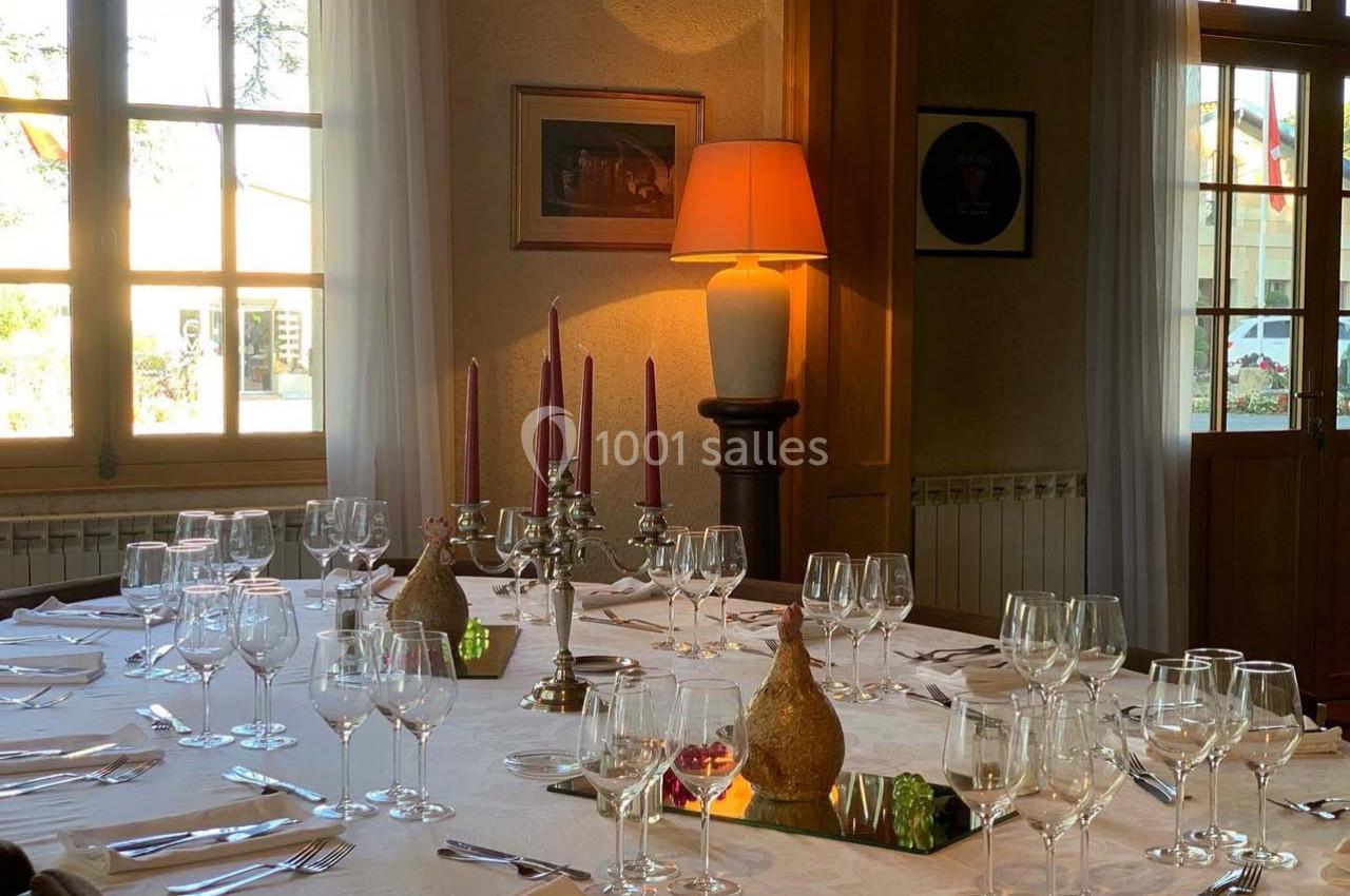 Location salle Moulis-en-Médoc (Gironde) - Château Maucaillou #26 Table dressée avec nappes blanches, verres, bougeoirs et décorations, dans une salle lumineuse avec fenêtres et lampes.